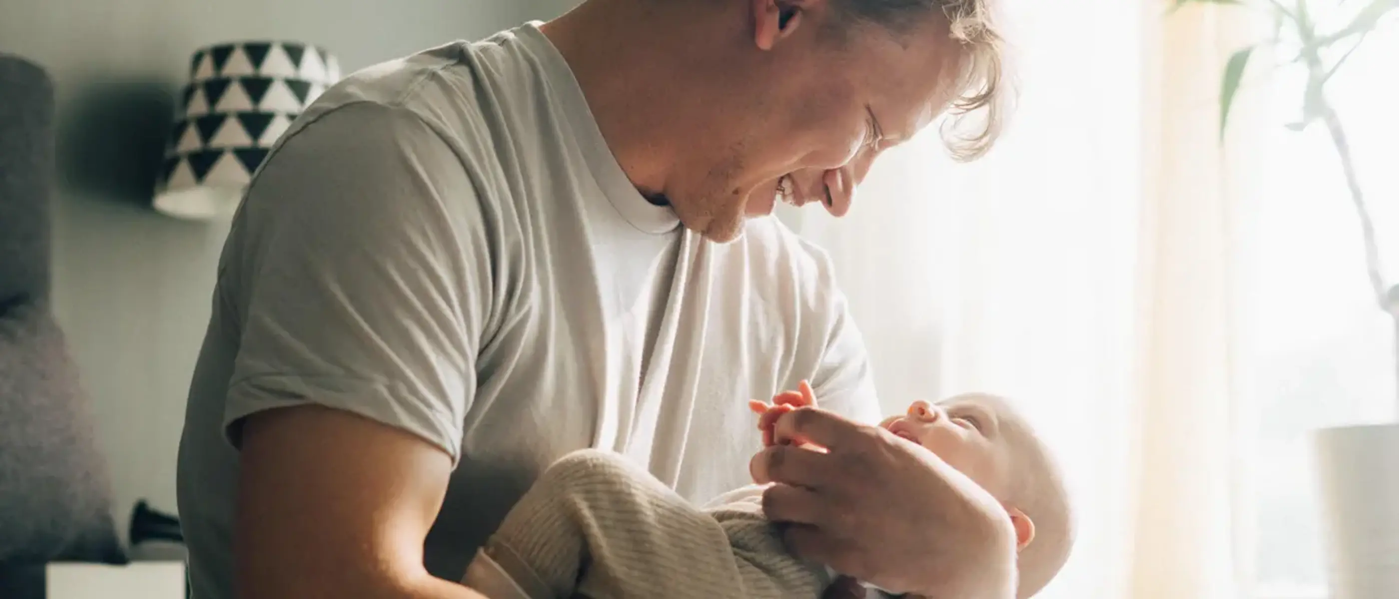 En pappa myser med sin lilla bebis.