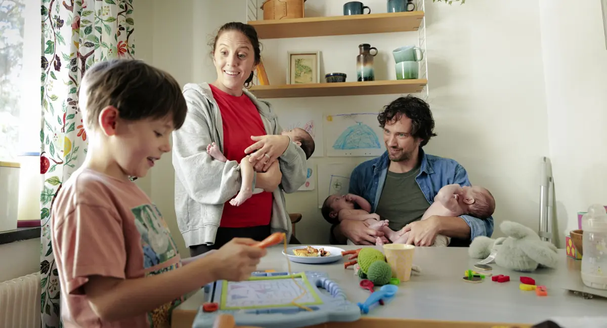 Familj som just fått trillingar pratar med första-barnet.