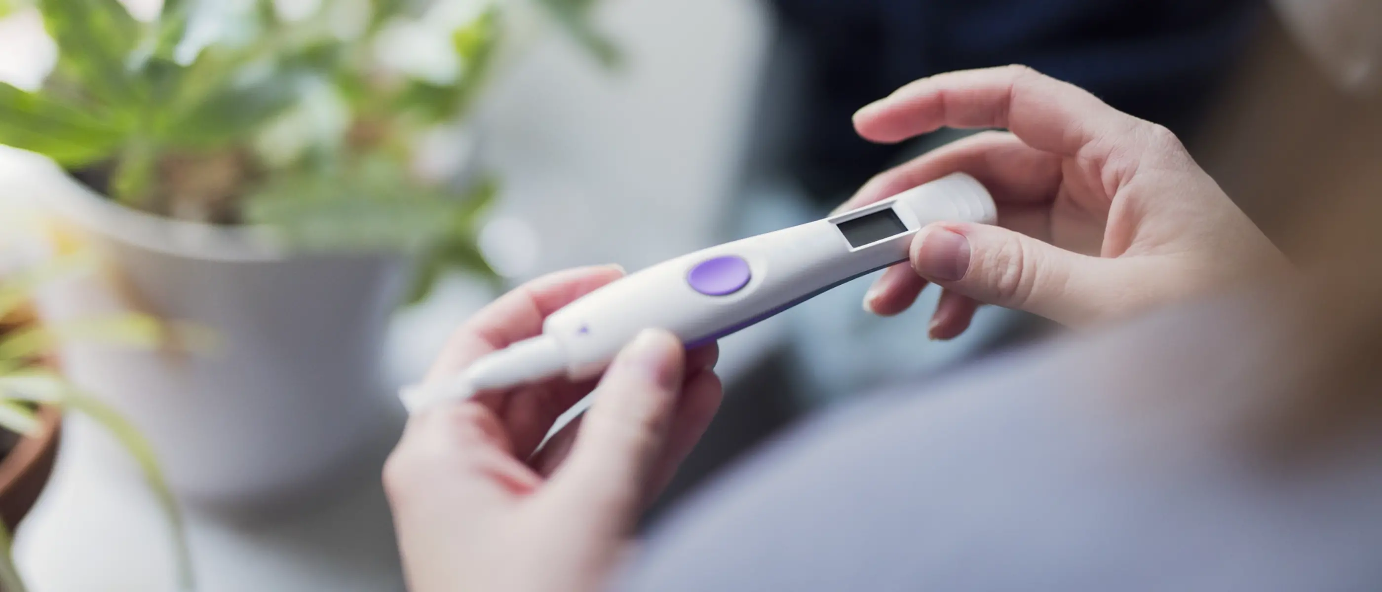 En kvinna håller i ett positivt graviditetstest.