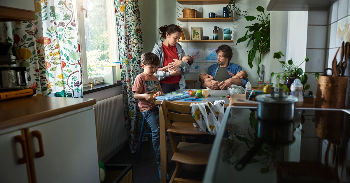 Flerbarnsfamilj i ett kök som ser ut att blivit för trångt.