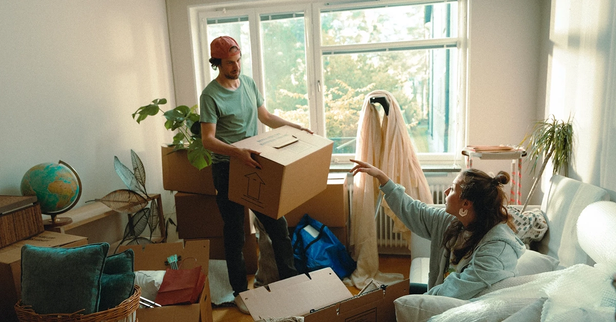 Ungt par i en lägenhet full av flyttkartonger.