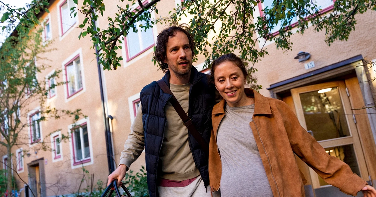 Par som går ut från ett trevåningshus.