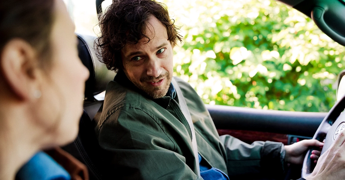 Par som sitter i en bil och tittar på varandra.