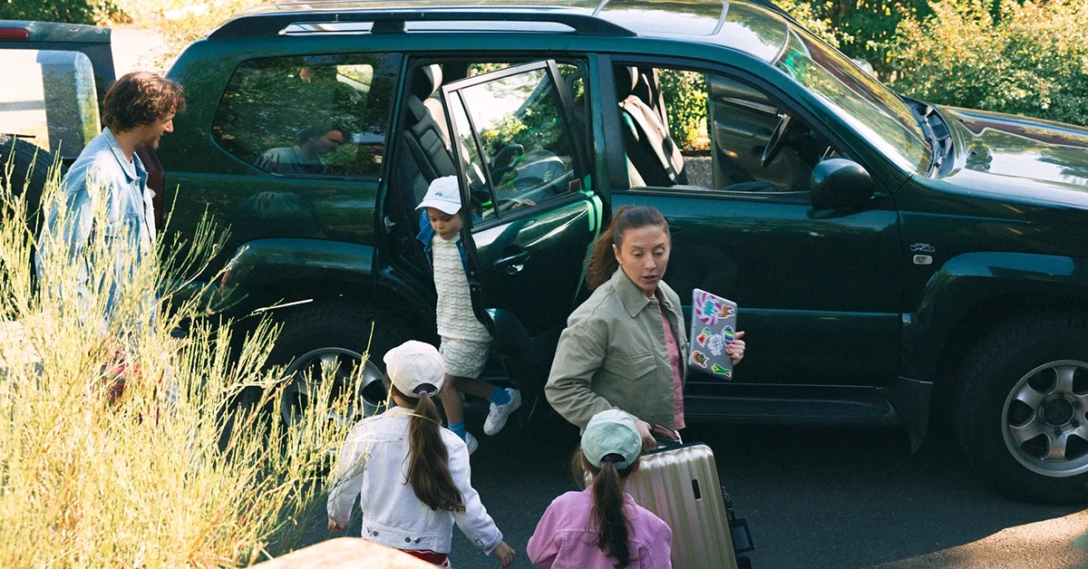 Familj som packar ut resväskor ur bilen.