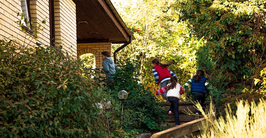Barn springer framför en villa.