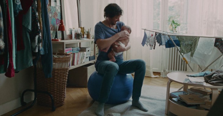 Pappa studsar på en medicinboll med nyfödd bebis.