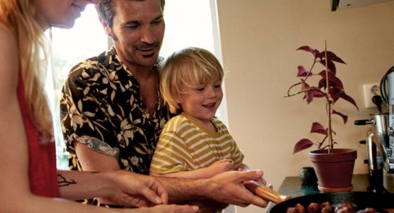 Par steker köttbullar tillsammans med sitt barn.