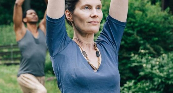 Personer yogar utomhus.