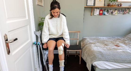 Tjej med bandagerat ben, foto