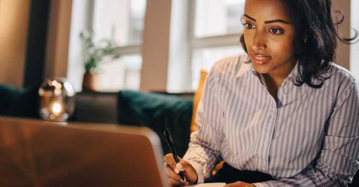 Kvinna sitter med en laptop. 