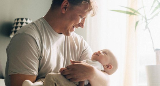 Glad pappa håller i bebis, bild.