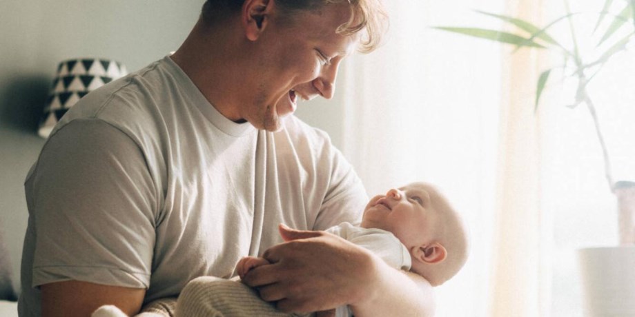 Pappa med bebis i famnen.