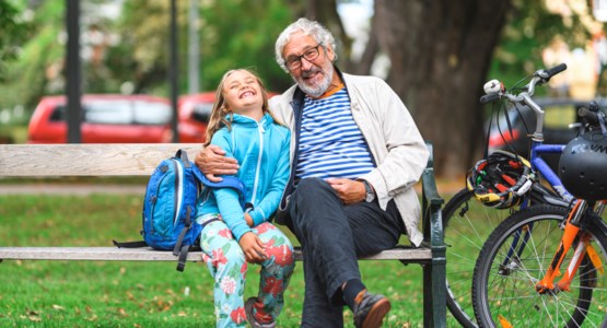 Man och flicka sitter på en parkbänk