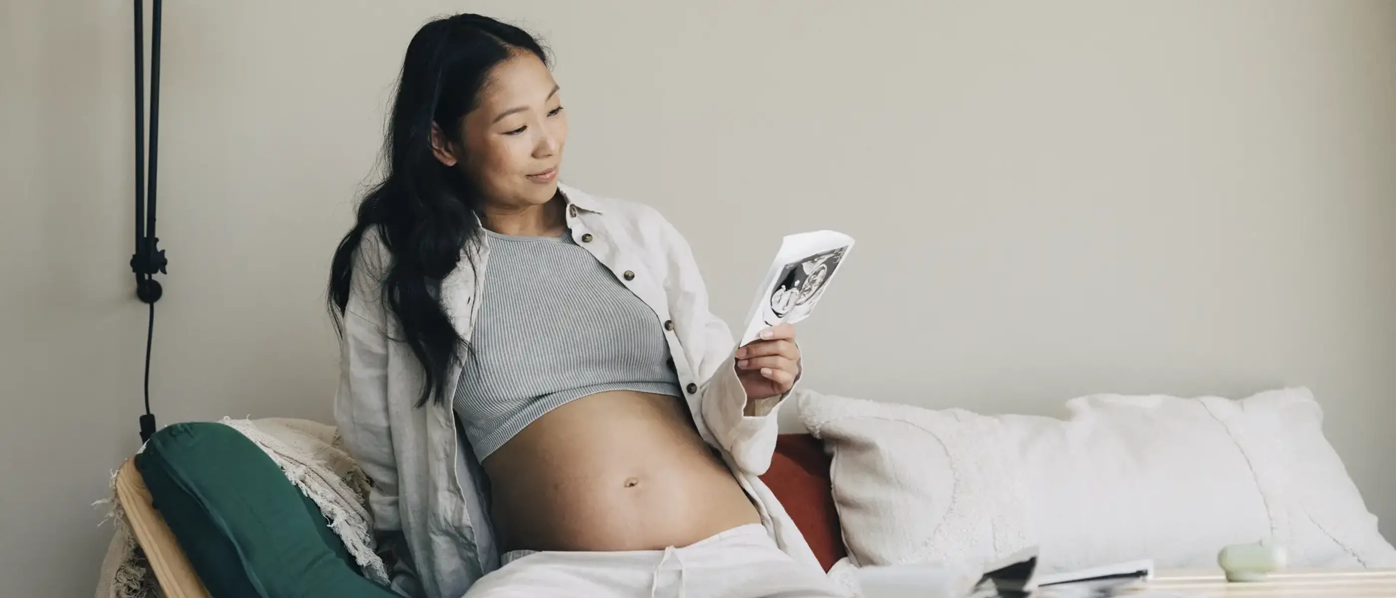 En gravid kvinna sitter avslappnat i en soffa.