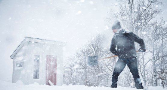 Man som skottar snö