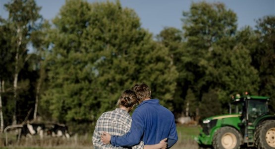 Två lantbrukare håller om varandra.