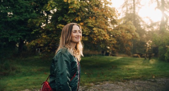 Kvinna går i solljus.