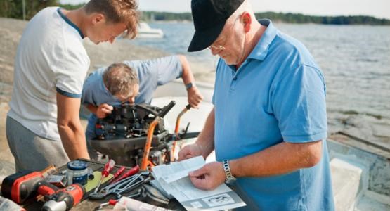 Män arbetar på båtmotor.