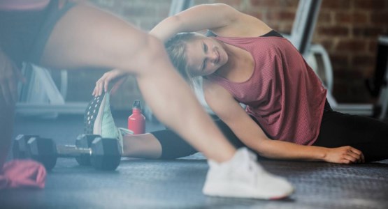 Kvinna stretchar på gymmet.