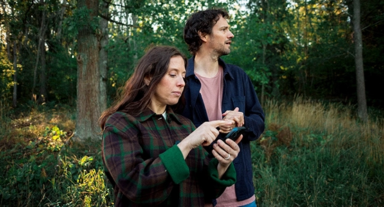 Kvinna läser om sin pension i sin mobil.