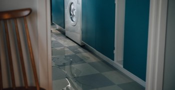 En diskmaskin i köket som läcker vatten.