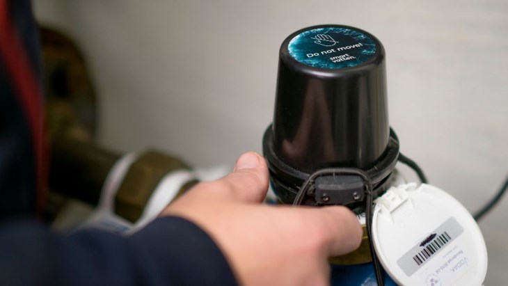 Person läser av en vattenmätare.