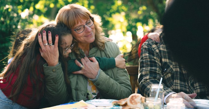 Mormor kramar om barnbarn i trädgården. 